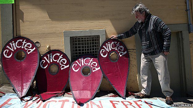 A protestor props up a sign during a demonstration outside of an apartment building that allegedly evicted all of the tenants to convert the units to AirBnb rentals on July 29, 2014 in San Francisco