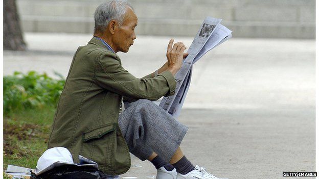 Elderly Korean man reading a paper