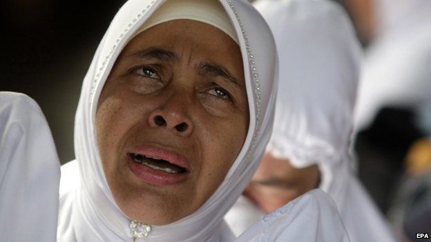 A woman cries at a mass grave in Banda Aceh, Indonesia. Photo: 26 December 2014