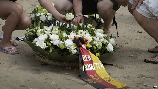 Relatives and friends of German victims of the Asian tsunami lay white roses on the beach during a commemoration and religious ceremony for German, Austrian and Swiss victims in Khao Lak, Thailand, Friday, Dec. 26, 2014