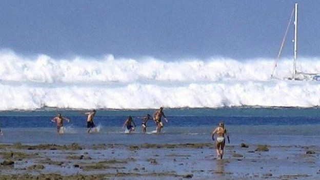File photo dated 26 December 2004 shows tourists caught by the first of six tsunami rolling towards Hat Rai Lay Beach, near Krabi in southern Thailand