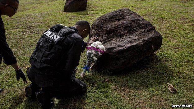 An Indonesian policeman prays at mass grave to commemorate the tenth anniversary of the Boxing Day tsunami on December 26, 2014 in Banda Aceh, Indonesia.