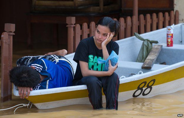 A woman (C) looks on as she waits inside a boat as her house submerged in floodwaters in Pengkalan Chepa, near Kota Bharu on December 27, 2014