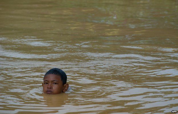 A boy plays in floodwaters in Pengkalan Chepa, near Kota Bharu on December 27, 2014