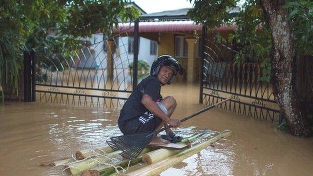 A man makes his way to his house submerged in floodwaters in Pengkalan Chepa, near Kota Bharu