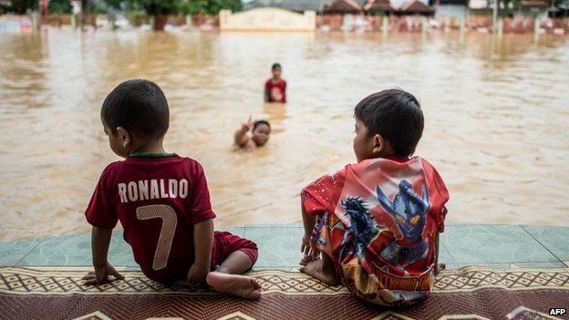 Boys play in Malaysian floodwaters