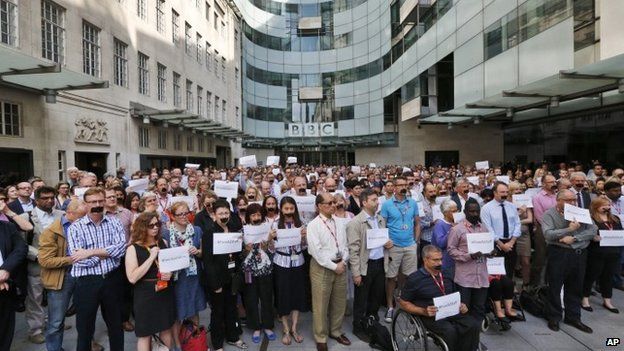 BBC journalists and staff, some with black tape over their mouths to illustrate the silencing of free speech and journalists around the world, hold a minute of silence in support of the jailed journalists in Egypt, outside BBC Broadcasting House in central London, Tuesday, June 24, 2014.