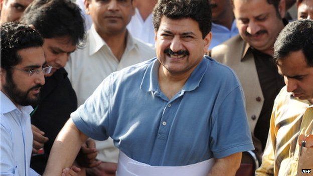 Leading Pakistani TV journalist Hamid Mir, (C), who survived an April attack by gunmen in Karachi, is surrounded by journalists as he leaves the Supreme Court in a wheelchair after his appearance before the judicial commission in Islamabad on May 19, 2014