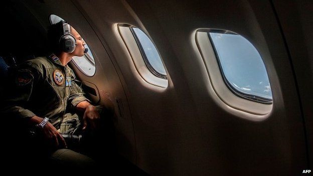 A member of the Indonesian military looks out of the window during a search and rescue operation for missing AirAsia flight QZ8501 - 29 December 2014