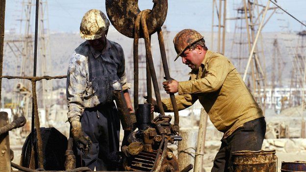 Oil workers operate on a well.