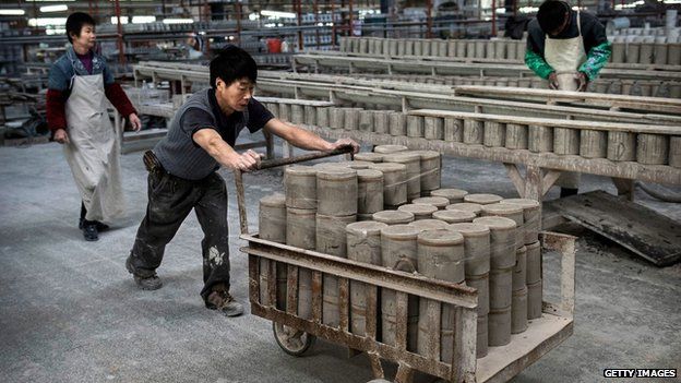 A Chinese worker pushes a cart full of clay in Dehua, Fujian Province, China.