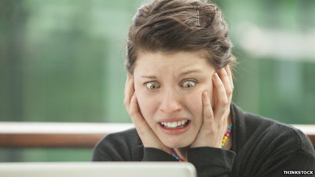 Woman looks desparingly at her computer screen