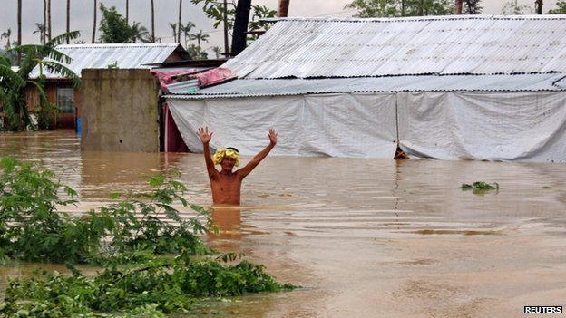 A resident wades through floodwaters brought on by heavy rains from tropical storm Jangmi, locally called Seniang, in Palo town, Samar province on 30 December 2014.
