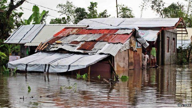Resident looks out from his home sitting in floodwaters brought on by heavy rains from tropical storm Jangmi, locally called Seniang, in Palo town, Samar province on 30 December 2014.