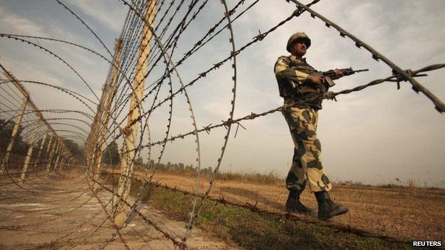 An Indian Border Security Force (BSF) soldier patrols near the fenced border with Pakistan in Suchetgarh, southwest of Jammu in this January 14, 2013 file picture