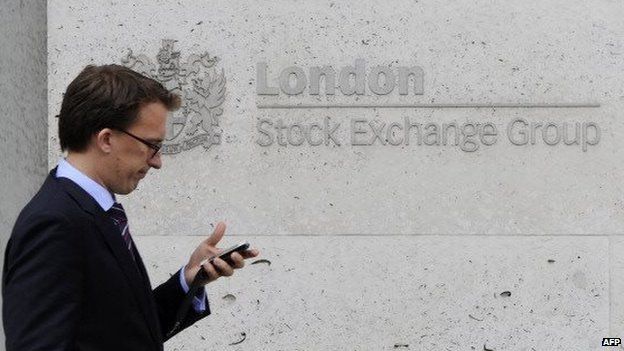 A man walks in front of the London Stock Exchange