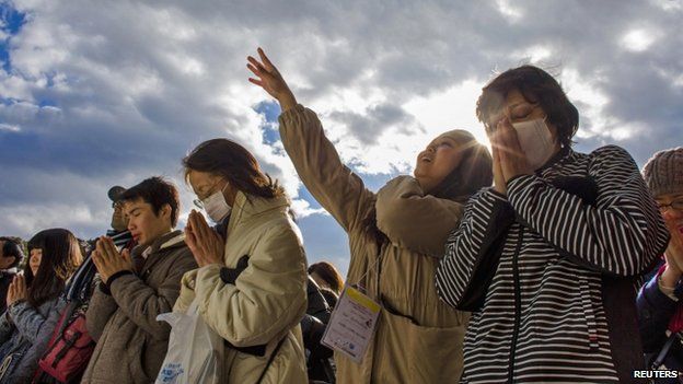 People pray and throw offerings for the new year at the Shinto Meiji Shrine in Tokyo (01 January 2015)