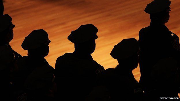 New York police officers stand in silhouette.