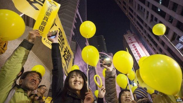 Pro-democracy activists release yellow balloons and hold signs saying "I want genuine universal suffrage" on New Year's Eve in Causeway Bay, Hong Kong, 31 December 2014