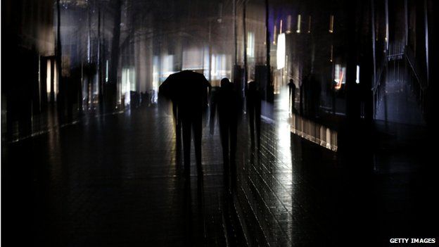 A man walks with an umbrella during a power outage in the Crimean city of Simferopol