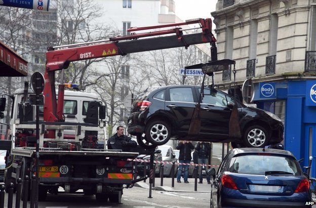 A truck tows the car used by armed gunmen who stormed the Paris offices of satirical newspaper Charlie Hebdo, killing 12 people, on 7 January 2015 in Paris.