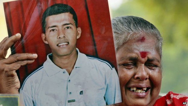 In this Nov. 15, 2013 file photo, a Sri Lankan ethnic Tamil woman cries holding a portrait of her missing son during a protest demanding answers about the thousands who went missing near the worst war"s end in 2009