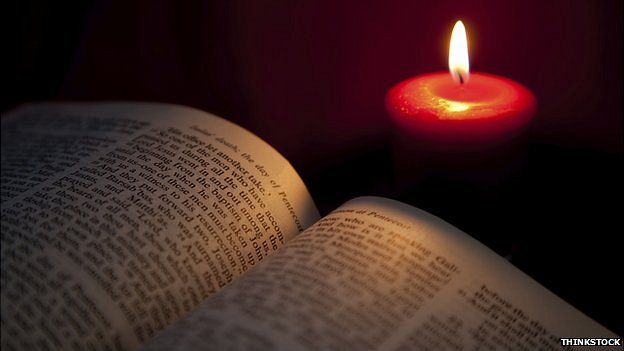 Открытая библия и свеча