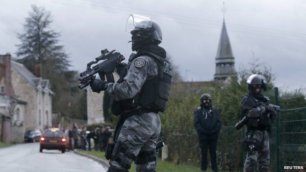 A member of the French GIPN intervention police forces secure a neighbourhood in Corcy, north-east of Paris on 8 January 2015.
