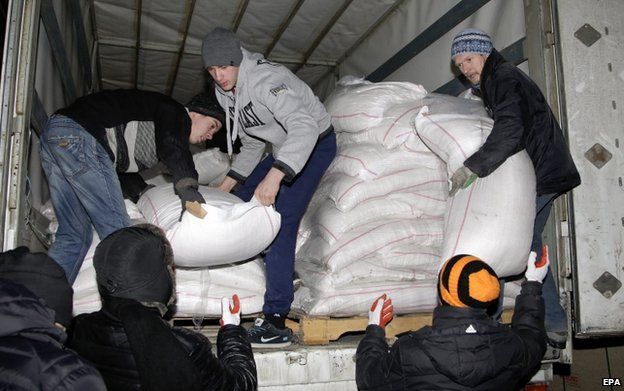 Workers unload a truck of a 11th Russian aid convoy, in Donetsk, Ukraine, 8 January 2015
