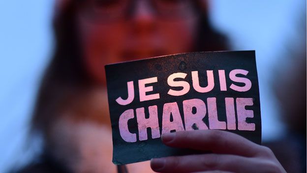 A woman holds a 'Je suis Charlie' sign