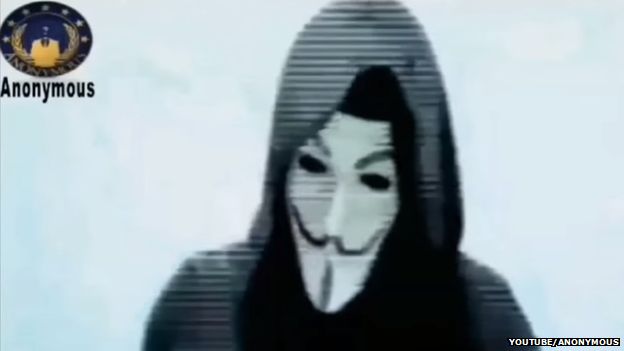 A hooded and masked man reads out a statement