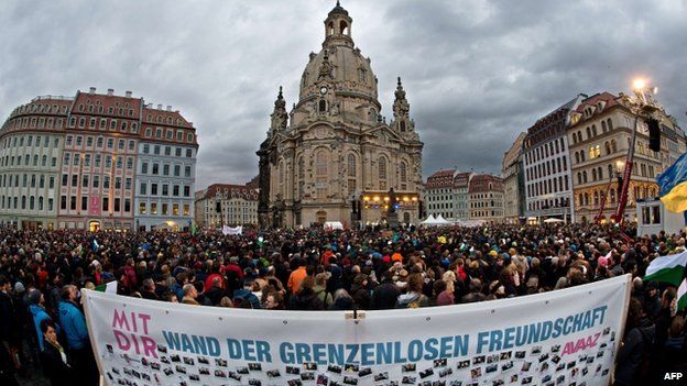 A banner reading "Wall of friendship without borders" can be seen in the foreground as thousands of people take part in the Dresden rally (10 January 2015)
