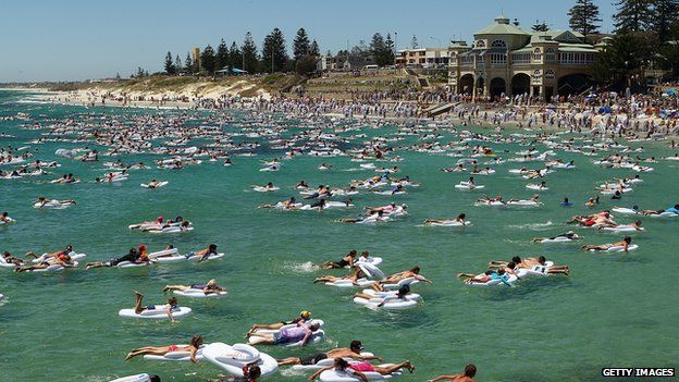 Beachgoers swim to shore after taking part in celebrations for Australia Day in Perth