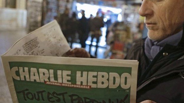 Jean Paul Bierlein reads the new Charlie Hebdo outside a newsstand in Nice, south-eastern France, 14 January 2015