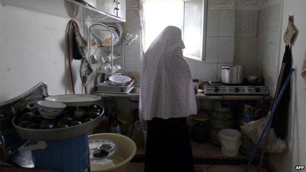 yrian refugee woman Umm Ammar cooks in a kitchen in her rented house in the Nazzal neighbourhood in Amman, Jordan, on May 30, 2012