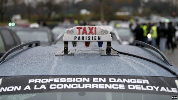 A banner glued on a taxi that reads "profession in danger, no to unfair competition" during a taxi drivers demonstration in Paris, France, 15 December 2014