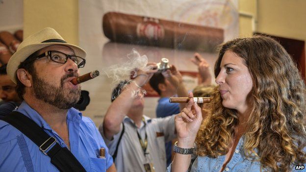 Man and woman smoke Cuban cigar at cigar festival in Havana on 27 February 2014