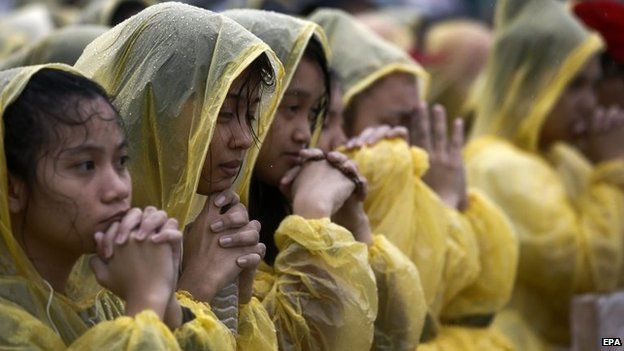 People pray for the victims of Typhoon Haiyan during the Mass in Tacloban