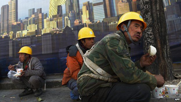 Workers eat lunch outside a construction site in Beijing