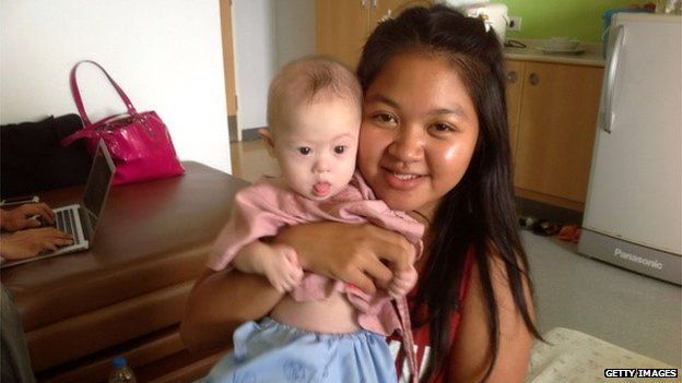 In this handout photo Thai surrogate mother Pattaramon Chanbua poses with baby Gammy at the Samitivej Hospital on August 6, 2014 in Chonburi province in Bangkok, Thailand.