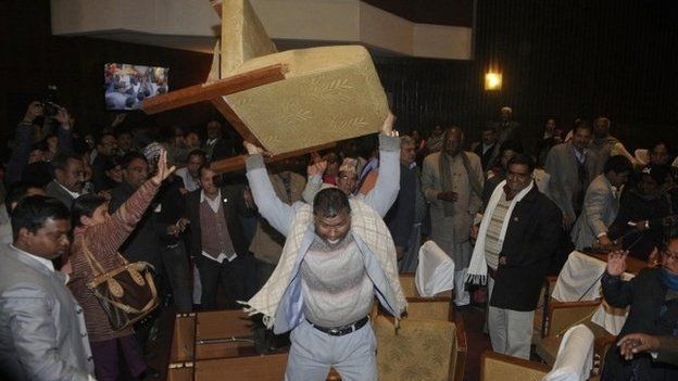 A constitution assembly member of an opposition party throws a chair during a meeting inside the Constitution Assembly building in Kathmandu January 20, 2015.