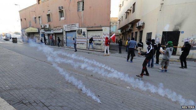 Protesters takes cover from tear gas fired by riot police during clashes in the village of Bilad Al Qadeem, south of Manama January 20, 2015