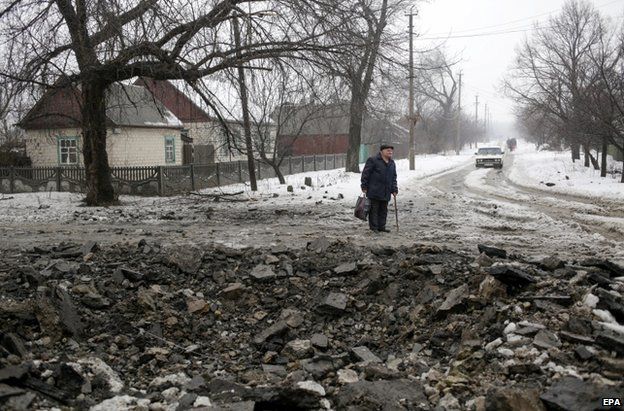 A man stands by a fresh crater in Debaltseve, Donetsk region, 20 January