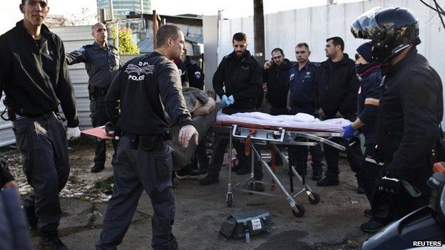 Israeli police officers carry on a stretcher a Palestinian man who stabbed up to 10 people in Tel Aviv, 21 January 2015