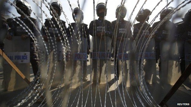 Nepalese riot police personnel stand guard in front of a barricade during a general strike in Kathmandu January 20, 2015.