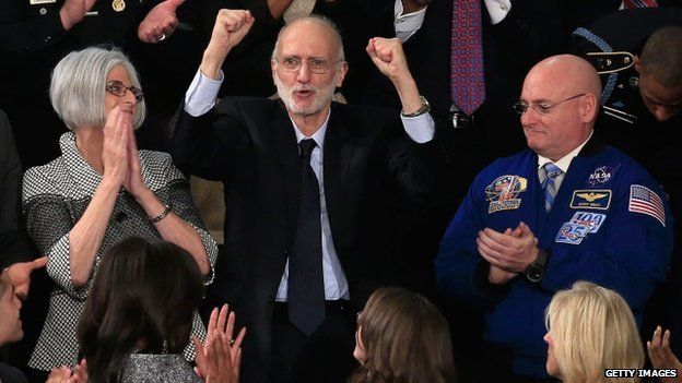 Alan Gross (C), recently freed after being held in Cuba since 2009, pumps his fist after being recognised by US President Barack Obama