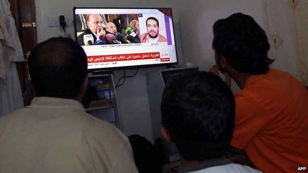 Men watch the news on a screen in Sanaa, 22 January