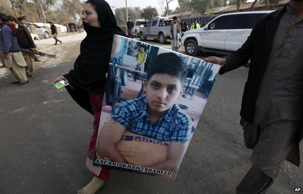 A Pakistani mother carries a picture of her son who was killed in the Taliban attack, January 14