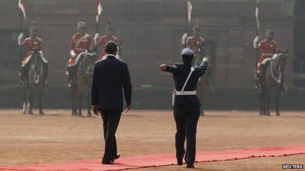 A female Indian officer walks in a ceremonial fashion beside U.S. President Barack Obama (L) as he reviews Indian troops in front of the Rashtrapati Bhavan presidential palace in New Delhi January 25, 2015.