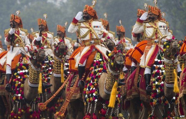 Indian military personnel salute while riding camels during the Republic Day Parade in Delhi on January 26, 2015